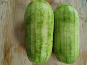 Raschiare la buccia della zucca pelosa con il dorso di un coltello, quindi lavarla.