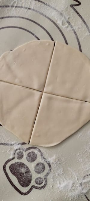 Einen Frühlingszwiebelpfannkuchen in 4 gleich große Teile teilen, die Apfelfüllung in die Mitte geben, von beiden Seiten halbieren und dann mit einer Gabel festdrücken.