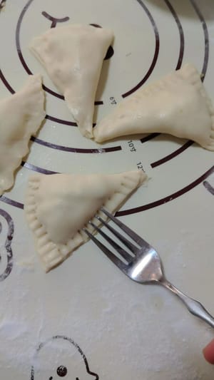 拿出一张手抓饼,平均分成4份,放入苹果馅,两边对折一下,再用叉子压紧就可以了