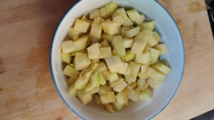 Den Apfel schälen, das Kerngehäuse entfernen und in kleine Würfel schneiden.