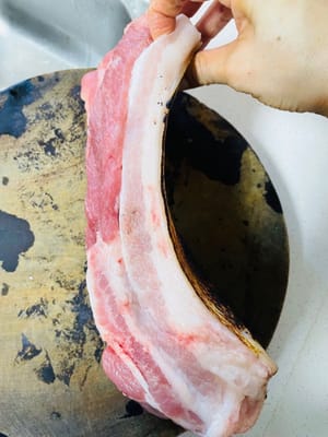 處理五花肉(燒皮+浸泡)
買五花肉的時候讓老闆幫忙燒一下豬皮,這樣能去掉豬皮上的髒東西,還能讓豬皮有焦香味。燒好後把肉放進冷水裡泡20分鐘,再用刀把豬皮刮乾淨,這一步別偷懶,刮乾淨了豬皮才會漂亮。