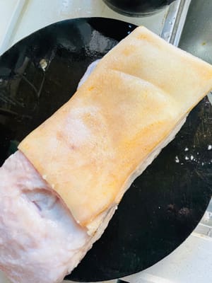Preparazione della Pancetta di Maiale (Rosolare la Cotenna + Ammollo)
Quando acquistate la pancetta di maiale, chiedete al venditore di rosolare la cotenna. Questo rimuoverà eventuali residui di sporco e conferirà un aroma bruciacchiato. Dopo la rosolatura, immergete la carne in acqua fredda per 20 minuti. Usate un coltello per raschiare la cotenna. Non lesinate su questo passaggio: una raschiatura pulita garantirà una pelle splendida.