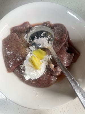 豚レバーの下味付け：水気を切った豚レバーに、薄口醤油大さじ1、白胡椒少々、塩、料理酒、生姜のスライス、片栗粉を加え、よく混ぜて10分間漬け込む。こうすることで、レバーが柔らかくなり、炒めたときに魚臭さがなくなる。