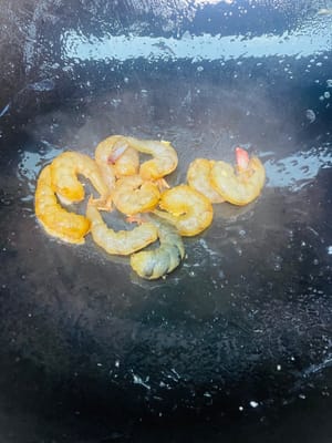Rocíe un poco de aceite en la sartén, vierta los camarones, saltee por un rato y reserve.