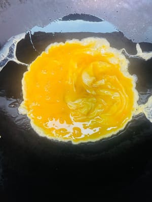 Calienta la sartén a fuego medio-bajo, agrega 2 cucharadas de aceite y luego vierte el líquido del huevo. Freír hasta que esté cocido y reservar.