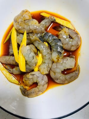 Pelar los camarones, abrir la espalda y retirar el hilo, agregar jengibre rallado, vino de cocina, pimienta blanca en polvo, salsa de soja ligera y vino de cocina y dejar marinar durante unos 10 minutos.