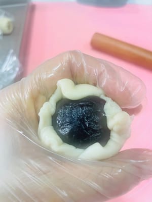 準備包製
將麵團壓扁擀圓，包上紅豆沙蛋黃餡，用虎口收緊，收口向下放焗盤，注意間距，蓋上保鮮膜保濕。