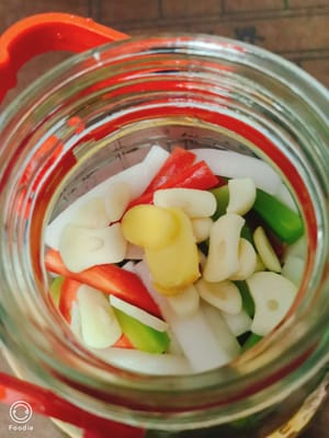 Cukup peras air berlebih dan masukkan ke dalam toples kaca. Dengan cara ini, jahe dan bawang putih tidak akan basi hingga Tahun Baru. Selanjutnya, tambahkan irisan jahe dan bawang putih yang telah disiapkan.