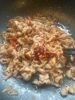 หลังจากนั้น นำเนื้อที่หั่นไว้ไปผัดในกระทะ แล้วใส่พริกป่นและโกชูจัง ตามด้วยน้ำตาล ซอสถั่วเหลือง พริกไทยขาว และเหล้าข้าว