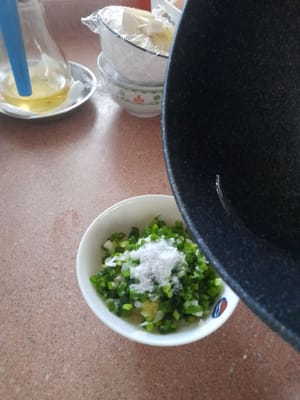 Prepare a frying pan, add 2 tablespoons of cooking oil, wait until hot, then pour on top (scallions, salt, ginger and finely chopped onions). Stir until well mixed.