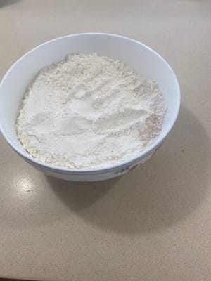 在碗中混合麵粉、3茶匙鹽、18克糖和所有酵母