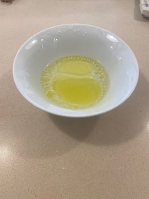 在另一個碗中加入 3 湯匙橄欖油和水
