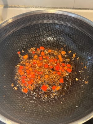 在熱鍋中倒入油，先炒蒜末和紅辣椒碎，然後加入豉油和蠔油，再炒一分鐘