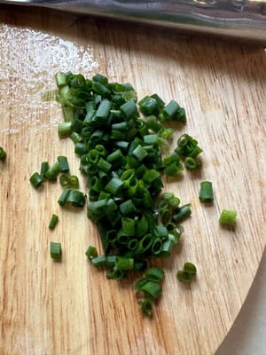 然後加入煮熟的魚，繼續翻炒。最後關火，加入蔥花。