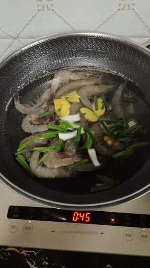 Portare l'acqua a ebollizione in una pentola, aggiungere cipollotti, zenzero e vino da cucina, quindi aggiungere i gamberi freschi e cuocere fino a cottura ultimata. Togliere i gamberi, sgusciarli e privarli dell'intestino.