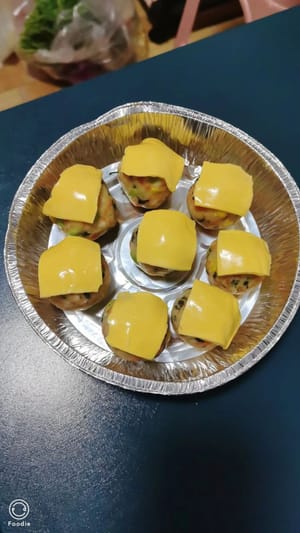 Con le mani nude, formare delle palline di impasto, disporle in una teglia, ricoprirle con le fette di formaggio, condire con un po' di ketchup e condimento per insalata e guarnire con semi di sesamo nero.