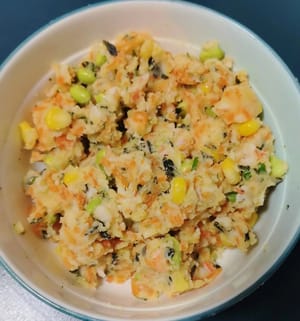 Schiacciare le fette di patate al vapore con una forchetta, aggiungere 1 grammo di sale, chicchi di mais, piselli verdi, carote a dadini, alghe tritate e pepe e mescolare bene.