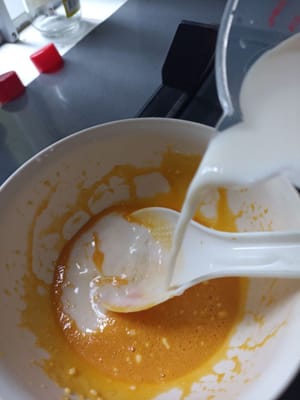 Tambahkan 250 ml susu kedalam kocokan telur aduk aduk sampai tercampur rata dan saring adonan puding