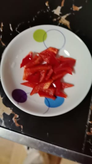 Tagliare i peperoni rossi a forma di rombo e disporli uno alla volta sul ripieno di carne avvolto.