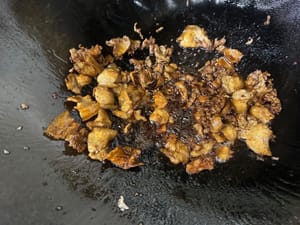 鍋中再放適量油，放入五花肉片煸炒，小火慢煎至出油表面金黃