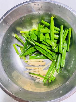Coupez le gingembre en lamelles et les oignons verts en tronçons et réservez.