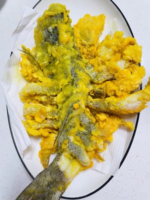 Une fois le poisson frit, sortez-le et placez-le sur du papier absorbant pour égoutter l'huile.