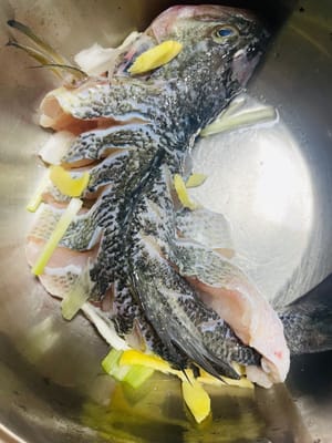 Saupoudrer un peu de sel, d'oignons émincés et de poivre blanc sur le corps du poisson et laisser mariner pendant 15 minutes.