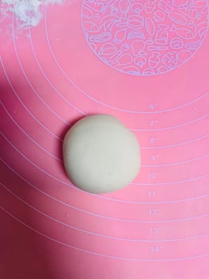 반죽을 둥글게 밀어 펴는데, 가운데는 두껍게, 가장자리는 얇게 만듭니다. 밀면서 돌려가며 밀어주면 두께가 고르지 않게 되거나 소가 새어 나오는 것을 방지할 수 있습니다. 팥소를 넣고 가장자리를 잘 봉하여 둥근 모양으로 만듭니다.