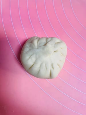 반죽을 둥글게 밀어 펴는데, 가운데는 두껍게, 가장자리는 얇게 만듭니다. 밀면서 돌려가며 밀어주면 두께가 고르지 않게 되거나 소가 새어 나오는 것을 방지할 수 있습니다. 팥소를 넣고 가장자리를 잘 봉하여 둥근 모양으로 만듭니다.