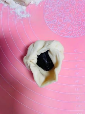 반죽을 둥글게 밀어 펴는데, 가운데는 두껍게, 가장자리는 얇게 만듭니다. 밀면서 돌려가며 밀어주면 두께가 고르지 않게 되거나 소가 새어 나오는 것을 방지할 수 있습니다. 팥소를 넣고 가장자리를 잘 봉하여 둥근 모양으로 만듭니다.