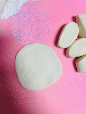 반죽을 둥글게 밀어 펴는데, 가운데는 두껍게, 가장자리는 얇게 만듭니다. 밀면서 돌려가며 밀어주면 두께가 고르지 않게 되거나 소가 새어 나오는 것을 방지할 수 있습니다. 팥소를 넣고 가장자리를 잘 봉하여 둥근 모양으로 만듭니다.