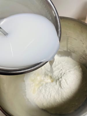 믹싱 볼에 드라이 이스트, 다목적 밀가루, 소금을 넣고 식힌 코코넛 워터를 부어 반죽이 매끄러워질 때까지 반죽합니다.