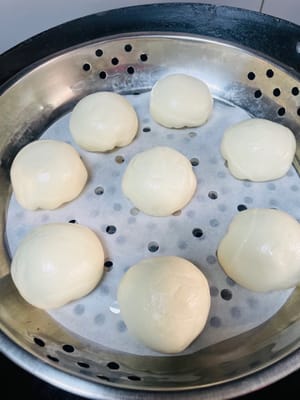 냄비에 담아 2차 발효를 시켜 원래 크기의 1.5배가 될 때까지 기다립니다. 물이 끓으면 12분간 찌고, 뚜껑을 열기 전에 3분간 그대로 둡니다.