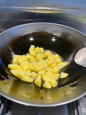 Faites chauffer le wok, ajoutez de l’huile et faites d’abord revenir les pommes de terre en utilisant plus d’huile.