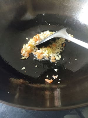 将蒜头、虾米和姜炒香。
