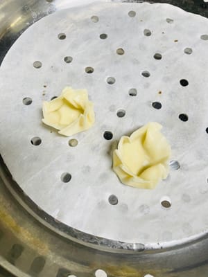 Spread some water around the edge of the back of the dumpling wrapper and pinch it into five or six pleats (the more pleats, the less filling you can fit; the fewer pleats, the more filling you can fit. Which is your preference?). Add the glutinous rice filling.
Use your thumb and forearm to tighten the wrapper, pressing and pinching it firmly to prevent it from falling apart during steaming.