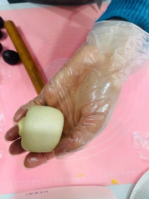 Ambil bola adonan yang sudah rileks, giling hingga berbentuk lembaran bulat, oleskan tipis pasta kacang merah di atasnya, gulung, giling sedikit lebih tipis, dan gulung lagi. Dengan cara ini, isian pasta kacang merah dapat tersebar lebih merata, tidak seperti saat membuat bakpao yang menggumpal di tengah dan terlalu manis saat digigit.