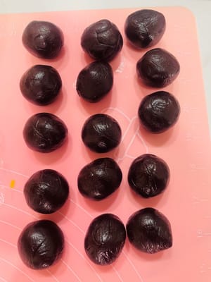 Bagi isian pasta kacang merah menjadi beberapa bagian kecil sesuai dengan jumlah bola adonan. Bentuk menjadi bola-bola, tutupi dengan kertas roti, dan pipihkan menjadi lembaran tipis dengan ukuran yang hampir sama dengan adonan roti. Sisihkan.