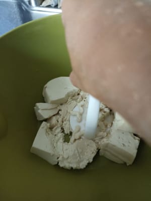 Tofu waschen, in Stücke schneiden und zerstampfen.