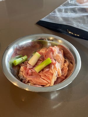 Den weißen Teil der Frühlingszwiebel zum Hähnchenschenkel geben