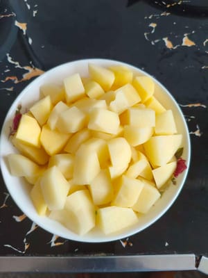 Pertama kupas kentang dan potong dadu
