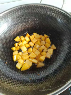 煎至表面金黃，然後倒入火腿丁150。