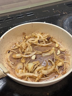 在同一个锅里，用五花肉分泌的油，翻炒洋葱片和大蒜，直到变软