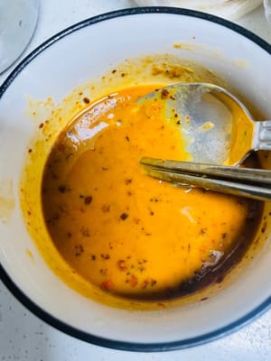 Preparare la salsa Soul Sesame (questo passaggio è essenziale per un sapore davvero delizioso)
1. In una ciotola capiente, aggiungere l'aglio tritato, i cipollotti tritati e il peperoncino in polvere.
2. Scaldare l'olio in un wok fino a farlo fumare (non cuocerlo troppo, altrimenti l'olio diventerà stantio). Quindi, spegnere il fuoco e lasciare riposare per 10 secondi. Versare rapidamente l'olio nella ciotola con il peperoncino in polvere. Si sprigionerà un aroma sfrigolante. Fare attenzione a non bruciare il peperoncino in polvere, altrimenti avrà un sapore amaro.
3. Quindi, aggiungere 2 cucchiai di salsa di soia leggera, 1 cucchiaio di aceto invecchiato, 1 cucchiaio di salsa di ostriche, 4 cucchiai di pasta di sesamo e 2 cucchiai di acqua bollita. Mescolare energicamente con le bacchette per distribuire la pasta di sesamo e rimuovere eventuali grumi. 4. Quindi, aggiungete 1 cucchiaio di zucchero (perfetto per esaltare il sapore), 1 cucchiaino di sale (poco, assaggiate per verificare la sapidità) e 7-8 grammi di pepe. Continuate a mescolare fino a ottenere un composto omogeneo. La salsa di sesamo è pronta.