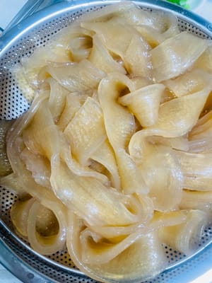 (너무 익히지 마세요. 너무 오래 익히면 질겨집니다.)
1. 큰 냄비에 물을 끓입니다. 불린 넓은 면을 넣고 2~3분간 삶습니다. 젓가락으로 면의 익힘 정도를 확인해 보세요. 딱딱하지 않으면 건져냅니다.
2. 면을 건져 찬물에 빠르게 헹굽니다(수돗물도 괜찮습니다. 이 과정을 생략하지 마세요). 물기를 완전히 빼주세요. 이렇게 하면 면이 쫄깃하고 서로 달라붙지 않습니다.