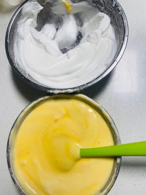 混合蛋白与蛋黄糊（一 ）：取 1/3 打发好的蛋白，放入蛋黄糊中，依然用 N 字手法快速翻拌均匀，动作要轻、要快，避免蛋白消泡，此步骤为初步混合，让蛋黄糊与蛋白初步融合。