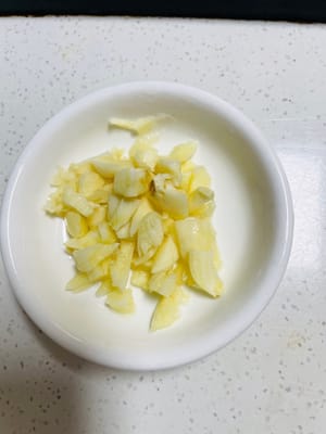 Potong jamur kering yang sudah direndam menjadi potongan-potongan kecil. Potong daun bawang menjadi potongan-potongan kecil, pisahkan daun bawang putih dan daun bawang cincang. Haluskan bawang putih dan sisihkan.