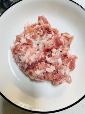 Siapkan daging babi giling. Anda bisa membelinya yang sudah jadi, atau membeli campuran daging berlemak dan tanpa lemak lalu memotongnya sendiri.