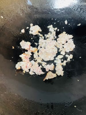 Panaskan wajan, semprotkan sedikit minyak (atau tuang 1 sendok makan minyak), masukkan daging babi cincang, kecilkan api, tutup wajan, masak selama 1 menit hingga daging babi cincang agak matang, aduk-aduk dua kali supaya tidak lengket di wajan.