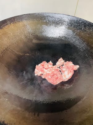 鍋子燒熱後噴一下油(或倒入1湯匙油),放入豬肉末,調小火蓋蓋1分鐘至肉末稍斷生,翻炒兩下,可以避免粘鍋。